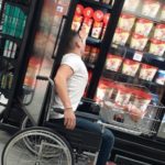 Fotografía de un usuario de silla de ruedas tomando bebidas de los refrijeradores para la evaluación de accesibilidad en zona de congelados