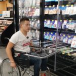Fotografía de un usuario de silla de ruedas productor de los estantes para la evaluación de accesibilidad en zona de pasillos
