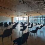 Fotografía del salón de responsabilidad social equipado con sillas y un ventanal con vista al patio