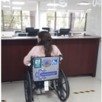 Fotografía de un usuario de silla de ruedas frente a los módulos de atención de la Oficialía de partes - Planta Baja