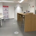 Fotografía de Acciona de Área de trabajo formato libre donde hay un escritorio alto de madera y sillas altas también donde pueden trabajar varias personas al mismo tiempo