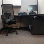 Fotografía de Schneider National Sede México de Estación de trabajo en la cual hay un escritorio con una computadora y una silla de oficina dentro del cubículo