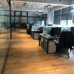 Fotografía de CEMEFI de las Oficinas donde se muestran los escritorios y sillas de trabajo los cuales se dividen por un cristal en medio del escritorio delimitando los espacios personales