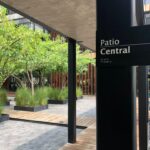 Fotografía de CEMEFI del Patio Central donde se aprecia el letrero con la leyenda "Patio Central" la cual está escrita también en Sistema Braille; y al fondo árboles plantados individualmente