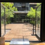 Fotografía de CEMEFI del Patio Central desde el interior del Auditorio donde se puede apreciar un gran patio con árboles y al fondo el edificio de CEMEFI