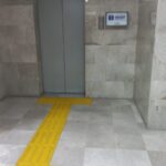 Fotografía del Elevador del Instituto Federal de Defensoría Pública en la que se puede apreciar el piso podotáctil que conduce al elevador