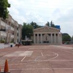 Explanada con canchas deportivas y de fondo una estructura de pilares