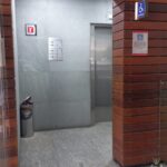 Fotografía donde se muestra la entrada a los elevadores y señalización del símbolo internacional de accesibilidad