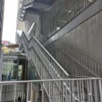 Escaleras que conducen a los diferentes pisos del edificio, hechas de metal y con barandal. Paredes acabado de concreto